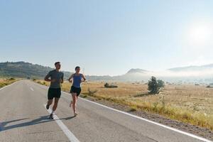 excité par le beauté de nature, une couple pouvoirs par leur Matin courir, leur corps et esprits revigoré. photo