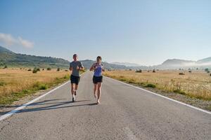 excité par le beauté de nature, une couple pouvoirs par leur Matin courir, leur corps et esprits revigoré. photo