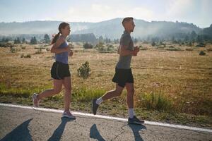 excité par le beauté de nature, une couple pouvoirs par leur Matin courir, leur corps et esprits revigoré. photo