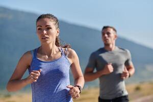 excité par le beauté de nature, une couple pouvoirs par leur Matin courir, leur corps et esprits revigoré. photo