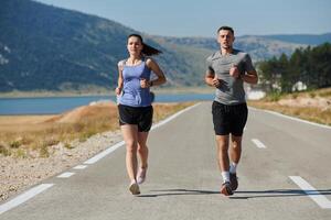 excité par le beauté de nature, une couple pouvoirs par leur Matin courir, leur corps et esprits revigoré. photo