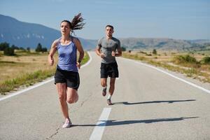 excité par le beauté de nature, une couple pouvoirs par leur Matin courir, leur corps et esprits revigoré. photo