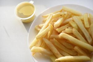 français frites sur une blanc assiette avec sauce. délicieux frit croustillant patates. photo