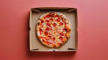 Pizza dans une boîte sur rose mur photo