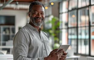 souriant noir homme en portant tablette ordinateur dans Bureau photo