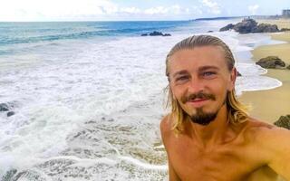 selfie avec rochers falaises vue vagues plage puerto escondido Mexique. photo