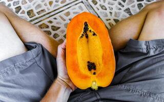 moitié Papaye dans main avec Contexte dans Mexique. photo