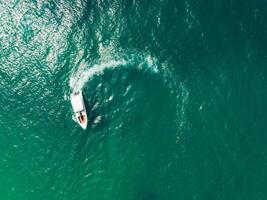 aérien vue de la vitesse bateau dans le aqua mer fabrication une cercle, drone vue photo