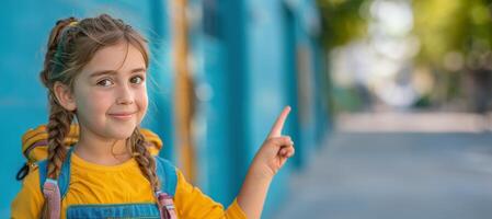 Jeune fille avec tresses points à le côté tandis que portant une sac à dos photo