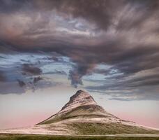 panoramique vue de kirkjufell Montagne en dessous de lourd des nuages photo