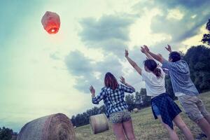 groupe de Jeune copains flottant sur une chinois lanterne photo