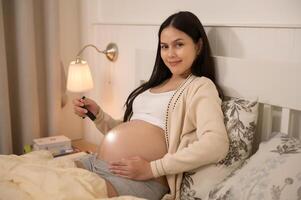 magnifique Enceinte femme en utilisant lampe de poche sur ventre à stimuler une de bébé développement, la fertilité infertilité traitement, FIV, futur maternité concept photo