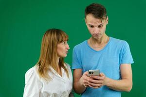 image de une Jeune couple en train de regarder une marrant sur mobile téléphone, posant sur isolé Contexte photo