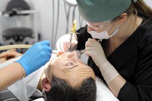 tirer une dent en dehors adulte homme prier avec le sien yeux regards à le médecin qui larmes le sien dent dentisterie fait mal le demande de une homme femme photo