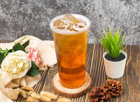 glacé ancien blé thé avec la glace cube servi dans jetable verre isolé n table côté vue de taiwanais boisson photo