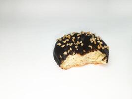 une mordu Chocolat Donut avec cacahuète morceaux isolé sur blanc Contexte. petit déjeuner Pâtisserie Donut. pièce pour texte. copie espace. photo