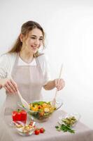 souriant Jeune femme portion Frais salade sur assiette vert végétalien salade avec mixte vert feuilles et des légumes tomates et Frais en bonne santé légume salade de Frais tomate, concombre, oignon, épinard, photo