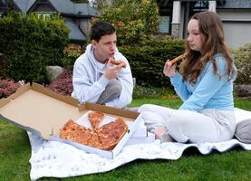 mal relation mal Date garçon agresseur réprimande fille séance en plein air dans mains Pizza fille dérangé adolescent Trier des choses en dehors disputes difficulté réprimande en colère offensé adolescent problèmes photo