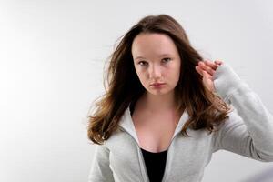 Jeune mixte course femme dans studio touche sa droit brillant cheveux photo