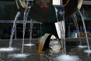 fontaine de le pionniers burard rue contre le toile de fond de bâtiment nous travail et grattes ciels ensoleillé journée chute l'eau écoulement vers le bas de une étrange bol cascade Fontaine de Vancouver ville photo