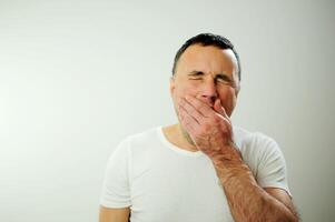 fatigué vouloir à sommeil ennui nostalgie tristesse homme bâillements, il fermé le sien yeux fermement et ouvert le sien bouche poilu mains mensonge sur le sien joues, il a noir cheveux et une gris émotions de une homme photo