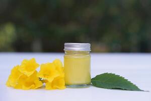 bouteille de fait maison thaïlandais à base de plantes pommade, baume.décoré avec Jaune fleur. concept, thaïlandais local sagesse à utilisation parfumé médicinal herbes à faire inhalateur et massage baume. photo