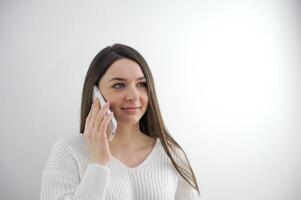 frustré brunette hispanique Jeune femme parlant par téléphone avec mari, dans troubles. jolie caucasien fille à Accueil en utilisant cellule téléphone à la recherche désespérément à la fenêtre. dérangé femme au foyer. maquette triste fille. photo