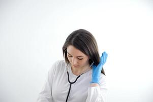 Jeune médecin est occupé examiner patient, visage est visible et le fille penché dans bleu gants avec phonendoscope stéthoscope, soins de santé, médecine, hôpital, traitement photo