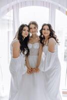 Trois femmes sont posant pour une image dans blanc Robes photo