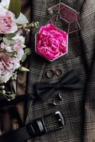 une homme tenue est orné avec une rose fleur, une cravate, et une arc photo