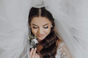 une femme avec longue cheveux et une voile est en portant une fleur photo