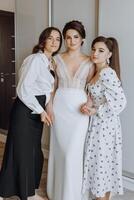 Trois femmes sont posant pour une photo, avec un de leur portant une blanc robe photo