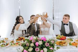 une groupe de gens sont célébrer une mariage, élevage leur des lunettes dans une pain grillé photo