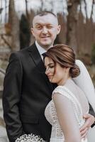 le la mariée et jeune marié sont en marchant dans la nature sur leur mariage journée. une homme câlins une femme. zhidka penche fermement contre sa mari photo