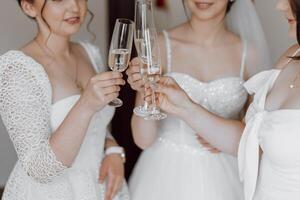 le femmes sont habillé dans blanc et sont souriant comme elles ou ils pain grillé à le un événement photo