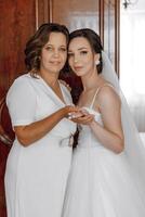 une femme dans une blanc robe est permanent suivant à une femme dans une mariage robe photo