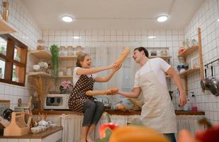 un jeune couple prépare un petit-déjeuner dans la cuisine avec un sourire et un bonheur amusants photo