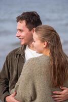 avec joyeux expressions, une couple jouit une espiègle moment par le mer, leur rire comme lumière comme le océan brise, une Date pour deux dans l'amour sur une bord de mer, la nature paramètre. photo