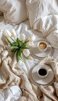 une tasse de café et une vase de fleurs sur une lit photo
