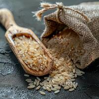 riz dans une jute sac et riz céréales sur une en bois cuillère photo