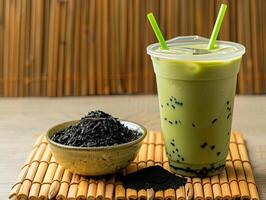 tasse de vert thé matcha Lait la glace boisson est mis sur le bambou tapis photo