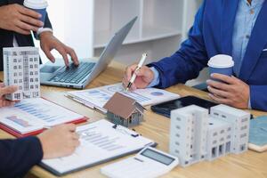 groupe de les hommes d'affaires et investisseurs discuter investir dans réel biens et conjointement plan investissements dans construction projets de copropriétés et appartements pour vente et louer. investissement consultatif concept photo