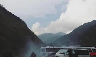 une groupe de gens permanent près une Montagne route photo