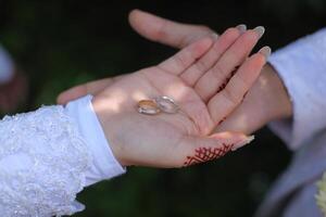 une paire de anneaux sur le mains de le la mariée et jeune marié photo