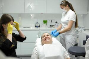 positif Enchanté femme séance dans cabinet de sa dentiste tandis que Faire vérification photo