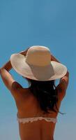 femme dans bikini et chapeau sur plage photo