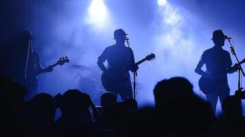 le silhouettes de Trois guitaristes orienté vers une façon les doigts en volant plus de le cordes comme elles ou ils confiture en dehors à une foule de désireux spectateurs. . photo