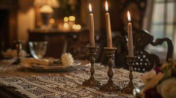 le à manger pièce dégage élégance et charme avec une étourdissant pièce maîtresse de vieilli laiton chandeliers séance un haut une dentelle nappe de table. doux aux chandelles danses de le complexe détails de photo