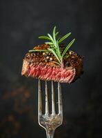 Romarin et en croûte de poivre steak sur une fourchette photo