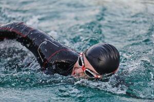 une professionnel triathlète les trains avec inébranlable dévouement pour un A venir compétition à une lac, émanant une sens de athlétisme et profond engagement à excellence. photo